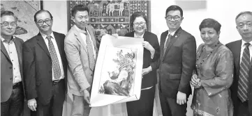  ??  ?? Chen presenting a souvenir to Christina. Also seen are Wilson (second left), Junz (third right) and Suzaini (second right).