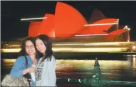  ?? PETER PARKS / AFP ?? Chinese tourists take photos in front of the Sydney Opera House, which is lit up red to welcome in the Lunar New Year in Sydney in February last year.