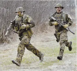  ??  ?? END TO SEARCH: Police run to the scene where suspect John Williams was apprehende­d during a manhunt yesterday.