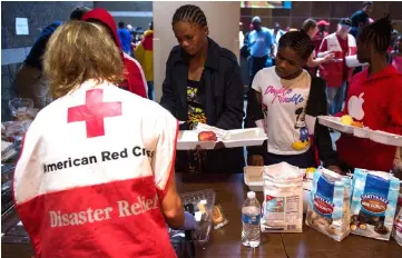  ?? — AFP photo ?? People wait for food inside an American Red Cross evacuation shelter in Chapel Hill, North Carolina.