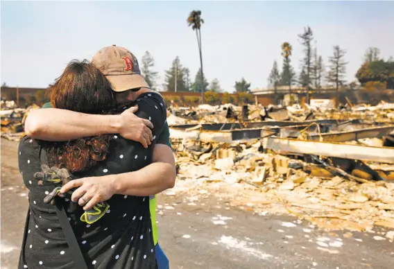  ?? Leah Millis / The Chronicle ?? Family members embrace at a destroyed home containing the remains, they believe, of a relative at Journey’s End mobile home park in Santa Rosa.