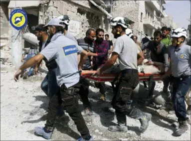  ?? SYRIAN CIVIL DEFENSE WHITE HELMETS VIA ASSOCIATED PRESS, FILE ?? In this Wednesday, Sept. 21, 2016, file photo, provided by the Syrian Civil Defense White Helmets, rescue workers move a victim from site of airstrikes in the al-Sakhour neighborho­od of the rebel-held part of eastern Aleppo, Syria. The call to get ready came at night. In the raging war zone of southweste­rn Syria, with enemy government forces on the march, the 98 White Helmets were told to bring spouses, children and but a few belongings to two collection points. Fabled rescuers themselves now in need of rescue, they embarked on a hair-raising journey through Israel, a supposed enemy, enroute to reluctant haven in Jordan, a country already burdened with multitudes of refugees.