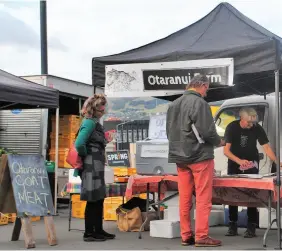  ??  ?? TOP / Nydia with sheep dog Nick. MIDDLE / Jozefa hand feeding her goats some of their favourite garden greens. ABOVE / Jozefa advises customers at Lyttelton Farmers Market on which goat meat cuts are best suited for curries or roasts.