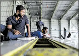  ?? Bloomberg News/DHIRAJ SINGH ?? Employees work on a Bombardier Inc. Q400 passenger aircraft undergoing maintenanc­e in August at Air Works Engineerin­g Pvt. in India’s Tamil Nadu state.
