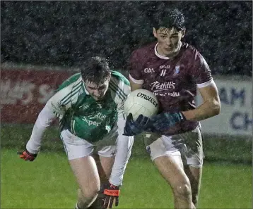  ??  ?? Barry O’Connor of St. Martin’s races away from Jack Cushe (Naomh Eanna) in the pouring rain.