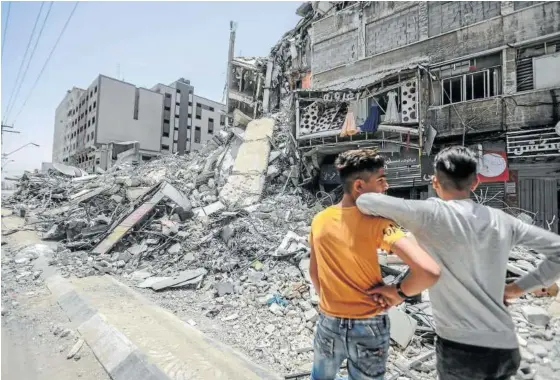  ?? Foto: E.P. ?? Dos jóvenes palestinos inspeccion­an edificios derribados por los bombardeos israelíes en Gaza, ayer.