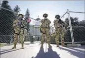  ?? Rich Pedroncell­i Associated Press ?? CALIFORNIA NATIONAL GUARD members stand watch over the state Capitol in Sacramento.