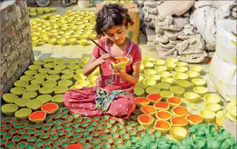  ??  ?? A young artist, Payal, paints earthen lamps ahead of Diwali in Amritsar on Monday. AFP