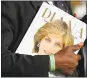  ?? FRANK AUGSTEIN — THE ASSOCIATED PRESS ?? A royal fan holds a book that remembers Diana, Princess of Wales, outside Kensington Palace in London on Thursday.