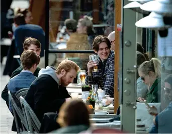  ??  ?? All’aperto
Giovani seduti nei dehors dei locali di Stoccolma. Il governo svedese ha deciso di tenere tutto aperto (Ap)