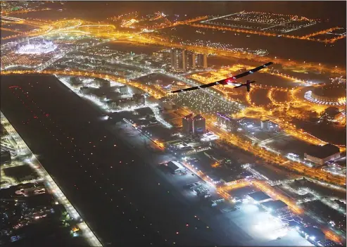  ??  ?? The Solar Impulse 2 plane (top right), flies over Al-Bateen Executive Airport (bottom), and the Sheikh Zayed Grand Mosque (top left), in Abu Dhabi, United Arab Emirates, shortly before landing on July 26. The world’s first ever round-the-world flight...