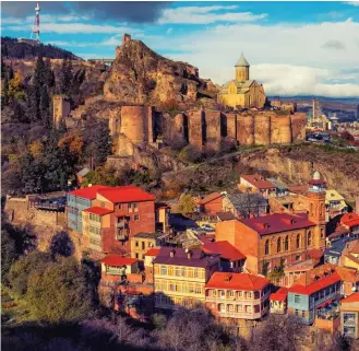  ??  ?? FROM TOP:
St Nicholas Church overlooks Tbilisi; the Bridge Of Peace spans the Kura River in the capital