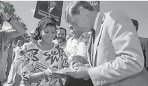  ?? KATHY WILLENS/AP ?? Florida Gov. Bob Graham signs an autograph for Maria Dulce before a campaign appearance at the Miami River Festival in Jean Marti Park on Oct. 25, 1986, in Miami.