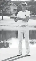  ??  ?? Justin Thomas poses with the winner’s trophy after winning the WGC - FedEx St. Jude Invitation­al golf tournament at TPC Southwind on Sunday in Memphis, Tenn.