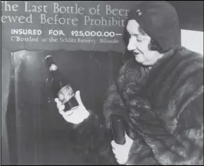  ?? ASSOCIATED PRESS ?? In this Dec. 29, 1930 file photo, Rae Samuels holds the last bottle of beer that was distilled before prohibitio­n went into effect in Chicago.