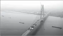  ?? WEI DONGSHENG / FOR CHINA DAILY ?? The constructi­on of the main structure of a highway bridge over the Yangtze River is completed in Wuxue, Hubei province, on Tuesday. The 3,355- meter bridge connects Wuxue on the northern bank with Hubei’s Yangxin county in the south.