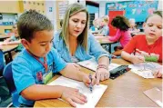  ?? [PHOTO BY STEVE SISNEY, THE OKLAHOMAN] ?? Kindergart­en teacher Jessica Trent shows Andrew Martinez some writing skills. This photo was taken last year at Cleveland Elementary School in Norman.