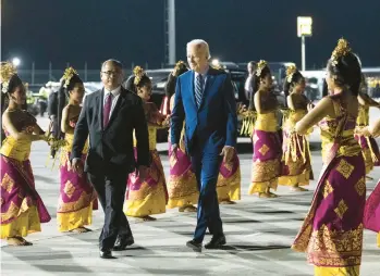  ?? DOUG MILLS/THE NEW YORK TIMES ?? President Joe Biden walks past Balinese dancers after arriving Sunday in Bali, Indonesia.