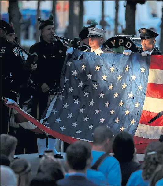  ?? Picture Chip Somodevill­a ?? Members of the New York police and fire department­s, including pipe bands, hold a flag for the national anthem at the 9/11 Memorial, New York yesterday on the 20th anniversar­y of the September 11 terrorist attacks