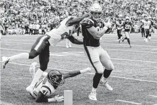  ?? Brett Coomer / Staff photograph­er ?? Patriots tight end Rob Gronkowski (87) beats Texans defensive back Kareem Jackson (25) and linebacker Zach Cunningham (41) for a touchdown in the first quarter Sunday.