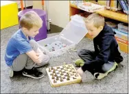  ?? Lynn Atkins/The Weekly Vista ?? Twins Wyatt and Cole Jones play their own style of chess after the preschool storytime at the Bella Vista Library last week.