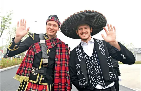  ??  ?? Dos participan­tes de la Expo visten los trajes tradiciona­les de Escocia y México .