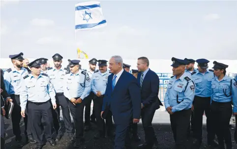  ?? (Reuters/Ronen Zvulun) ?? PRIME MINISTER Benjamin Netanyahu attends the inaugurati­on ceremony of a police station in an Arab town in 2017. Deputy Commission­er Jamal Hakroush is fifth from right.