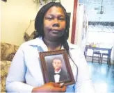  ?? AP PHOTO/RUSS BYNUM, FILE ?? Jameillah Smiley holds a framed photograph of her son, Ricky Boyd, at her home in Savannah, Ga., in April. Police were justified in fatally shooting the 20-yearold Boyd, a grand jury said Wednesday.