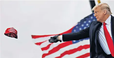  ??  ?? US President Donald Trump tosses out ‘Maga’ (Make America Great Again) caps as he arrives for a rally in Michigan