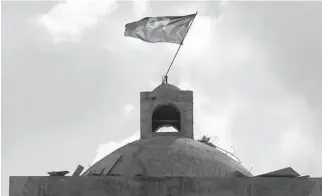  ?? JOSE A. IGLESIAS/MIAMI HERALD ?? A Haitian flag dances in the wind at the highest point of the new St. Gerard Catholic Church in the historic Carrefour-Feuilles neighborho­od of Port-au-Prince, Haiti. For nearly three months, constructi­on ground to a halt.