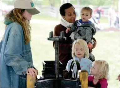  ?? JONATHAN TRESSLER — THE NEWS-HERALD ?? Six-year-old Emma Pepple, in blue, and her 3-year-old sister, Julia, try their hands at apple cider-making at Lake Metroparks’ Apple Butter &amp; Cider Festival Sept. 22 at Farmpark in Kirtland.