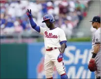  ?? MATT SLOCUM ?? The Phillies’ Andrew McCutchen, left, reacts past Yankees second baseman Rougned Odor after hitting a double off Domingo German in the second inning Sunday in Philadelph­ia.