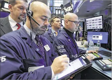  ?? RICHARD DREW / ASSOCIATED PRESS ?? Fred DeMarco (left) and Mario Picone (right) work on the floor of the New York Stock Exchange on Thursday. Stocks moved broadly lower, giving back the market’s gains from the day before. At one point, the Dow Jones industrial average was down more than...