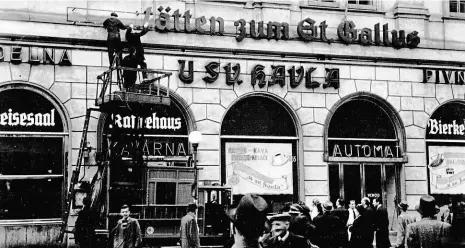  ?? Foto: VÚA-VHA, Praha ?? Dolů s tím! Odstraňová­ní německých nápisů na jídelně U Sv. Havla v Rytířské ulici v Praze 5. května 1945.