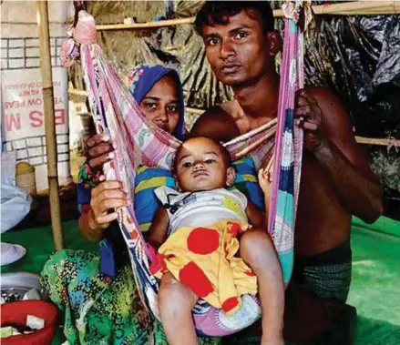  ?? IPS PIC ?? Rohingya couple Mohammad Faisal, his wife Hajera and their child at a camp at Teknaf Nature’s Park, Bangladesh. Some refugees walked 96km to reach Bangladesh.