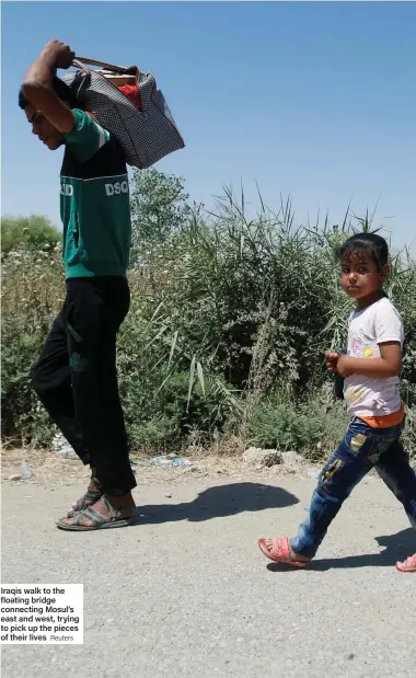  ?? Reuters ?? Iraqis walk to the floating bridge connecting Mosul’s east and west, trying to pick up the pieces of their lives