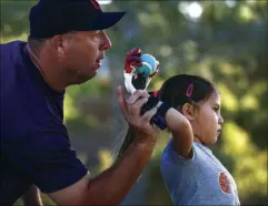  ?? Joel Angel Juarez Las Vegas Review-Journal ?? Coach Tom Hallett and Hailey Dawson practice her opening pitch Thursday at Anthem Hills Park in Henderson for Game 4 of the World Series.