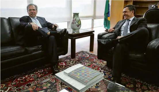  ?? Sérgio Lima/AFP ?? O futuro ministro da Economia, Paulo Guedes, é recebido pelo ministro da Fazenda, Eduardo Guardia, no gabinete, em Brasília