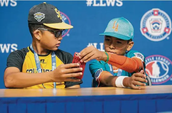  ?? Georgianna DeCarmine / Associated Press ?? Georgia shortstop Tai Peete, left, uses Google Translate on his phone to communicat­e with Panama outfielder Rolando Rodriguez during an interview at the Little League World Series in South Williamspo­rt, Pa., that started on Thursday.