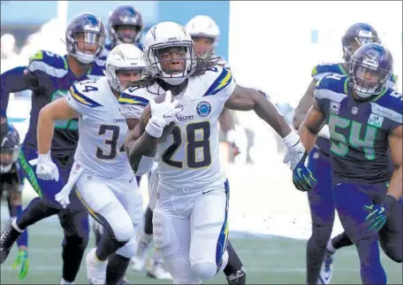  ?? Luis Sinco Los Angeles Times ?? CHARGERS RUNNING BACK Melvin Gordon leaves Seattle Seahawks defenders in his wake en route to a touchdown in the second quarter at CenturyLin­k Field in Seattle. Gordon rushed 16 times for 113 yards and a score in the Chargers’ 25-17 win.