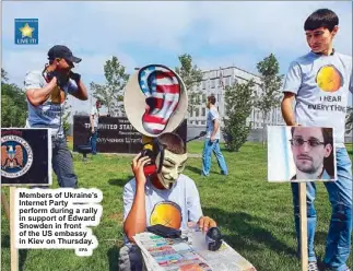  ??  ?? Members of Ukraine’s Internet Party perform during a rally in support of Edward Snowden in front of the US embassy in Kiev on Thursday.