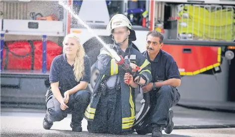  ?? RP-FOTOS (2): STEPHAN KÖHLEN ?? Nadine Bondieck, Pascal und Thorsten Rapp üben den Löschangri­ff bei der Feuerwehr.