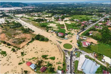  ??  ?? Deep trouble: Roads and homes totally and partially submerged after the river burst its banks in Kota Belud.