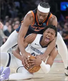  ?? Mary Althaffer/Associated Press ?? Memphis’ GG Jackson, bottom and New York’s Precious Achiuwa wrestle for a loose ball Tuesday night in New York. The Knicks won, 123-113.