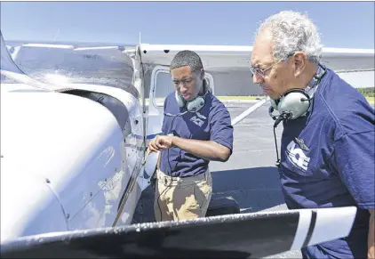  ??  ?? Julius Alexander (right), founder of ACE Academy, observes Leon complete a flight check on a Cessna plane at Fulton County airport. Leon hopes to be a commercial pilot one day.