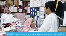  ?? — Xinhua ?? KUWAIT: People shop at a clothing store to prepare for Eid Al-Fitr in Kuwait City.