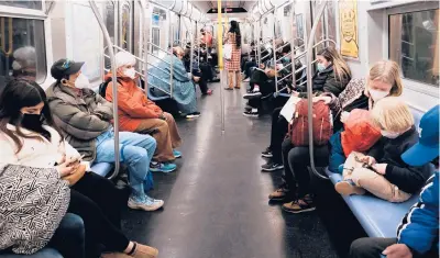  ?? SPENCER PLATT/GETTY ?? Riders on a subway train on March 11 in New York City. A federal rule calling for masks on mass transit remains in place.