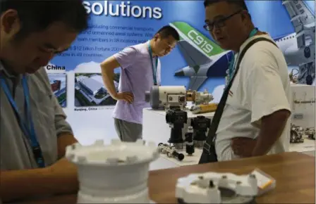  ?? ANDY WONG — THE ASSOCIATED PRESS ?? In this photo, visitors look at airplane component parts on display at Aviation Expo China in Beijing. China On Wednesday vowed to take measures of the “same strength” in response to a proposed U.S. tariff hike on $50 billion worth of Chinese goods in...