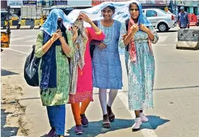  ?? ‘chunni’ K. DURGA RAO ?? Girls covering their face with to protect themselves from scorching summer heat while heading home from college, on Wednesday. —