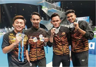  ??  ?? Glittering harvest: Malaysian divers (from left) Gabriel Gilbert Daim, Mohd Syafiq Puteh, Jellson Jabillin and Hanis Nazirul Jaya Surya showing their medals won in the Australia Diving Grand Prix in Gold Coast.